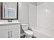 Bathroom with a subway tiled shower, toilet, and vanity with a dark framed mirror above at 247 Franklin Rd, Atlanta, GA 30342