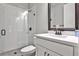 Bathroom with a tiled shower with glass, toilet, and vanity with a framed mirror above at 247 Franklin Rd, Atlanta, GA 30342