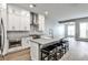 Modern, all-white kitchen featuring an island with barstool seating and stainless steel appliances at 247 Franklin Rd, Atlanta, GA 30342