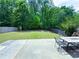 Expansive backyard with a patio area perfect for outdoor dining and entertaining, surrounded by mature trees and a fence at 545 Eldridge Dr, Suwanee, GA 30024