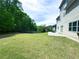 Large backyard with a combination of lawn and wooded area, plus a patio providing opportunities for relaxation and outdoor enjoyment at 545 Eldridge Dr, Suwanee, GA 30024
