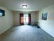 Large, carpeted bonus room with a window, tv and space for exercise equipment at 545 Eldridge Dr, Suwanee, GA 30024