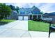 Beautiful two-story brick home with a manicured lawn, covered porch, and a long driveway at 545 Eldridge Dr, Suwanee, GA 30024