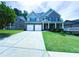 Inviting two-story brick home with a manicured lawn, covered porch, and a two-car garage at 545 Eldridge Dr, Suwanee, GA 30024