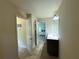 Hallway with tiled floors leading to a bathroom featuring a sink with vanity and an open door at 545 Eldridge Dr, Suwanee, GA 30024