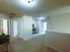 Bright hallway with neutral carpet, multiple doors, decorative plants, and artwork creating a warm atmosphere at 545 Eldridge Dr, Suwanee, GA 30024