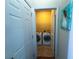Convenient laundry room with side-by-side washer and dryer, shelving, and tiled flooring for easy maintenance at 545 Eldridge Dr, Suwanee, GA 30024