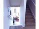 Carpeted staircase leads up to a bright, inviting hallway with decorative artwork and natural light at 545 Eldridge Dr, Suwanee, GA 30024