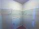 Spacious walk-in closet with metal shelving and door access to attic space, providing ample storage solutions at 545 Eldridge Dr, Suwanee, GA 30024