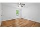 Bedroom with wood-look flooring, ceiling fan, and bright windows, plus white walls at 901 Gettysburg Pl, Atlanta, GA 30350
