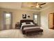 Spacious main bedroom featuring a tray ceiling, ceiling fan, and plush bed at 911 Park Place St, Social Circle, GA 30025