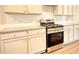 Modern kitchen with white cabinets, stainless steel appliances, and light granite countertops at 911 Park Place St, Social Circle, GA 30025