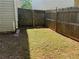 Fenced backyard area shows grass and dirt patch with a view of the wooden fence on a sunny day at 269 Privet Cir, Suwanee, GA 30024