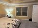 Comfortable bedroom boasts tray ceilings, neutral carpet, and ample natural light from a window at 269 Privet Cir, Suwanee, GA 30024