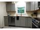 Updated kitchen features gray cabinets, granite counters, stainless appliances and a window over the sink at 875 Eleanor Nw Ct, Atlanta, GA 30318