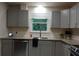 Kitchen area with gray cabinets, a stainless steel dishwasher, and a black towel by the sink at 875 Eleanor Nw Ct, Atlanta, GA 30318