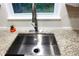 Close up of stainless steel kitchen sink with granite countertops and a bright window view at 875 Eleanor Nw Ct, Atlanta, GA 30318