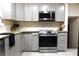 This kitchen boasts stainless steel appliances, gray cabinets, granite countertops and modern lighting at 875 Eleanor Nw Ct, Atlanta, GA 30318