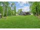 Expansive backyard features lush lawn, mature trees, and a charming covered deck perfect for outdoor enjoyment at 1675 Commonwealth Trl, Cumming, GA 30041