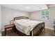 Cozy bedroom featuring hardwood floors, a shuttered window, and a comfortable bed at 1675 Commonwealth Trl, Cumming, GA 30041