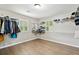 Large walk-in closet featuring adjustable shelving and ample storage space with wood plank flooring at 1675 Commonwealth Trl, Cumming, GA 30041