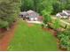 Aerial view of gray home with a large yard and a two-car garage surrounded by green trees at 1675 Commonwealth Trl, Cumming, GA 30041