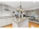 Bright kitchen with island, granite counters, stainless appliances, white cabinets and hardwood floors at 1675 Commonwealth Trl, Cumming, GA 30041