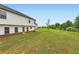 Large, grassy backyard with a view of the home's exterior at 229 Prescott St, Locust Grove, GA 30248