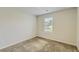 This bedroom features neutral walls, carpeted floors, and a window allowing natural light at 229 Prescott St, Locust Grove, GA 30248