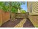 Fenced backyard with mulch, pathway, and convenient gate access at 3562 Greenwich Ave, Duluth, GA 30096