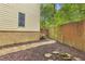 Landscaped backyard with stone pathway, brick foundation, and wooden fence at 3562 Greenwich Ave, Duluth, GA 30096