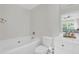 A well-lit bathroom features a bathtub, toilet, and a white vanity with elegant fixtures at 3562 Greenwich Ave, Duluth, GA 30096