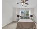 A neutral bedroom with a ceiling fan and a window view showcasing a glimpse of the neighborhood at 3562 Greenwich Ave, Duluth, GA 30096