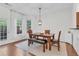 Bright dining room with a wood table, bench seating, and view of the outdoors through white-framed windows at 3562 Greenwich Ave, Duluth, GA 30096