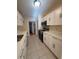 Galley kitchen features white cabinets, stainless steel appliances, and ample counter space at 3575 Oakvale Road # 303, Decatur, GA 30034