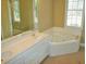 Bathroom showcasing a large mirror, dual sinks, a soaking tub, and natural light at 3592 Galdway Dr, Snellville, GA 30039