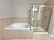 Bright bathroom featuring a tiled tub and separate glass-enclosed shower at 5872 Oakbrook Lake Ct, Norcross, GA 30093