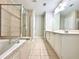 Bathroom features a soaking tub, glass shower, dual vanities, and tile flooring at 5872 Oakbrook Lake Ct, Norcross, GA 30093