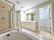 Bathroom features a soaking tub, glass shower, dual vanities, and tile flooring at 5872 Oakbrook Lake Ct, Norcross, GA 30093