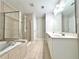 Bathroom features a soaking tub, glass shower, dual vanities, and tile flooring at 5872 Oakbrook Lake Ct, Norcross, GA 30093