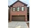 Two-story brick home with a brown garage door and matching shutters at 5872 Oakbrook Lake Ct, Norcross, GA 30093