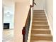 A carpeted staircase features wood railing and a view of the living room at 5872 Oakbrook Lake Ct, Norcross, GA 30093