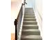 Carpeted staircase features a wooden handrail with black iron spindles at 5872 Oakbrook Lake Ct, Norcross, GA 30093