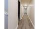 Hallway with light walls and modern lighting, featuring wood-look flooring at 11433 Panhandle Rd, Hampton, GA 30228