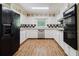 Kitchen featuring white cabinets, stainless steel appliances, and laminate flooring at 11433 Panhandle Rd, Hampton, GA 30228