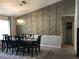 Elegant dining room features a striking accent wall and a modern chandelier over a dark wood table at 431 Crested View Dr, Loganville, GA 30052