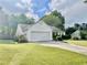 Well-maintained front yard with a lush lawn, mature landscaping, and a two-car garage at 431 Crested View Dr, Loganville, GA 30052