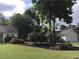 Home with landscaped yard featuring mature trees and flowering bushes at 431 Crested View Dr, Loganville, GA 30052