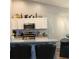Well-lit kitchen featuring white cabinets, granite countertops, stainless steel appliances, and modern bar stools at 431 Crested View Dr, Loganville, GA 30052