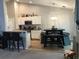 Open-concept kitchen with white cabinets, granite counters, stainless appliances, and a cozy dining area with a stylish light fixture at 431 Crested View Dr, Loganville, GA 30052